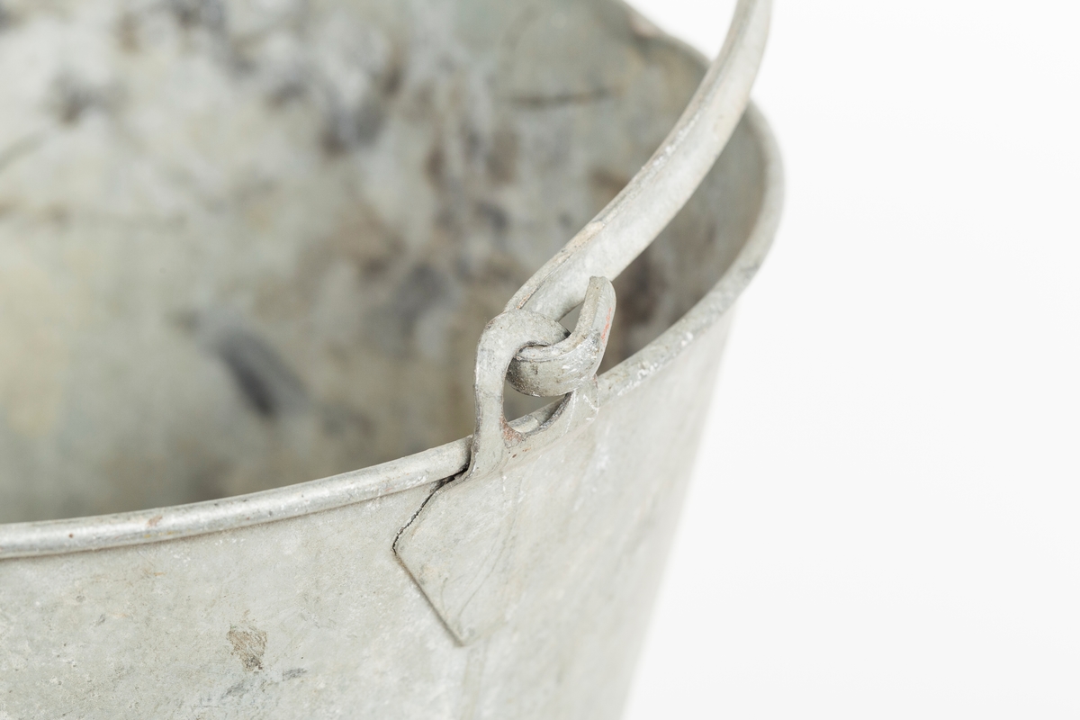 Grå metallbøtte med hank. Sotflekker på innsiden.