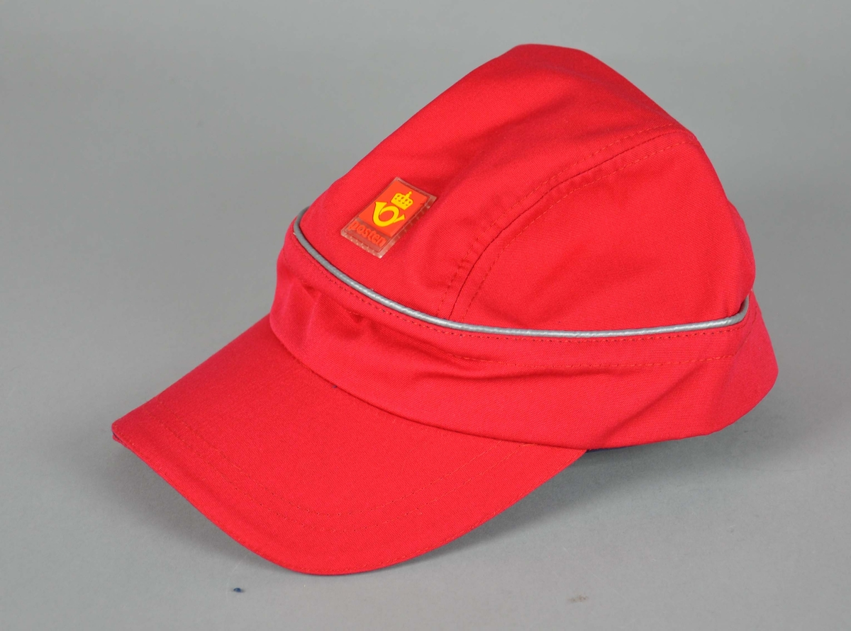Rød caps med Postens logo, blå foring på innsiden. Spenne bak med justering for størrelse. Medium størrelse.