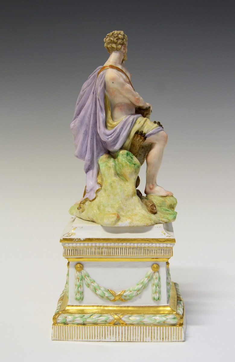 Herkules slåss mot en løve med bare hendene. Hans atributt, klubben ligger ved hans føtter, delvis under løven. De står på en underlag som imiterer gress. Under dette en kvadratisk sokkel med laurbærgirlandere i nyklassisistisk utførelse.