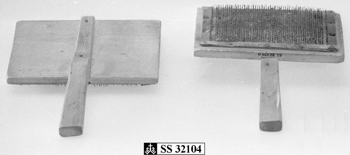 To treplater hvor innsiden av begge platene er dekket av  en skinnduk med tettsittende nåler. Begge treplatene har håndtak.