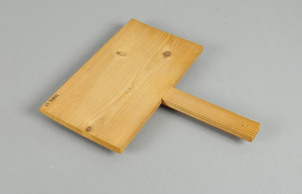 Treplate med håndtak, der den ene siden er dekket av en lærduk med tettsittende nåler.