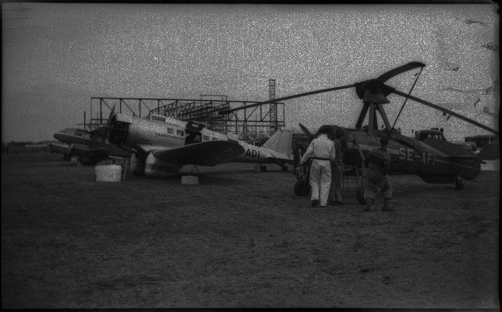 Bilder fra åpningen av den sivile flyplassen på Sømmesletta på Sola. Bildene viser folk som titter på flyene og helikoptrene som besøkte flyplassen fra inn- og utland i anledning åpningen. Det er flere bilder fra et stort passasjerfly fra Lufthansa med påskriften "Generalfeldmarschall von Hindenburg" og "D-APIS". Det er også et bilde fra en kanonbåt.