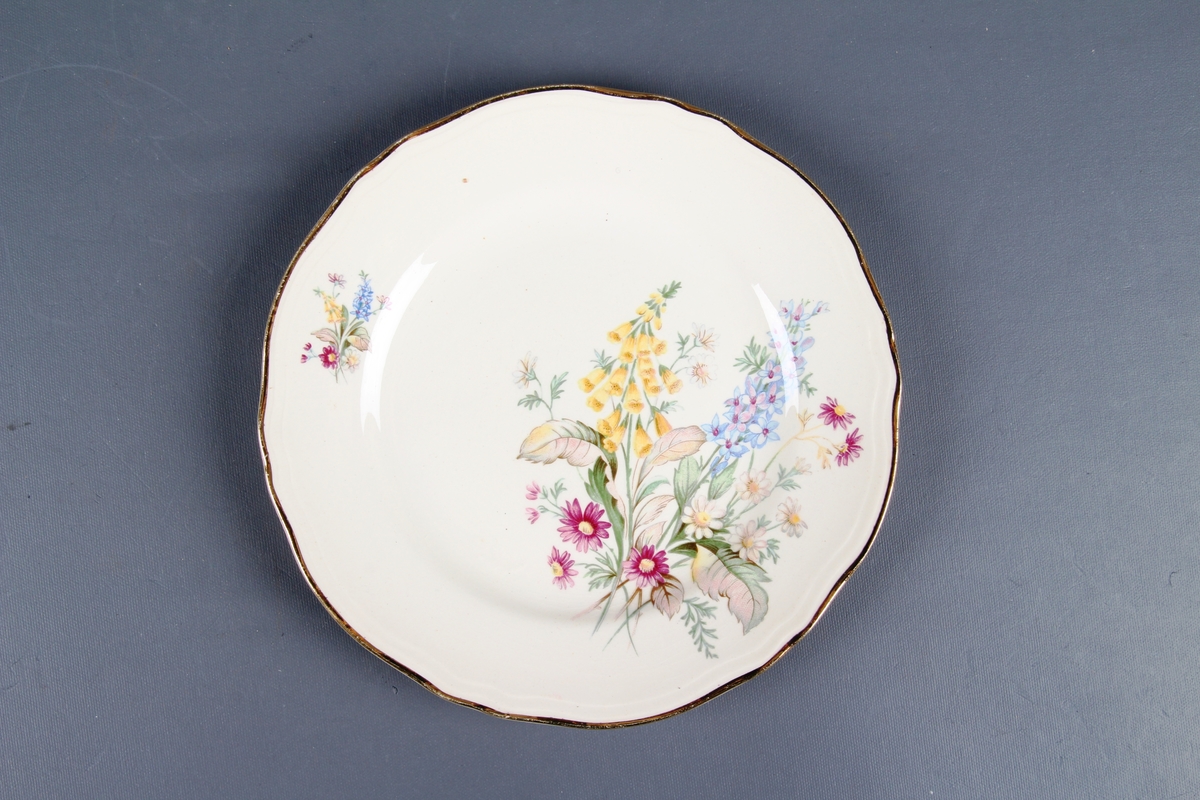 Tallerken med blomsterdekor og gullkant ytterst.