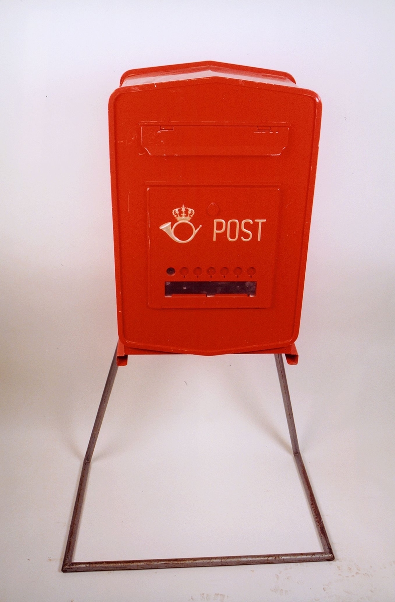 Rød mekanisk tømmepostkasse for tømmeapparat. Med posthornemblem og ordet Post i gul farge. Med felt for tømmetider og markering av når tømt