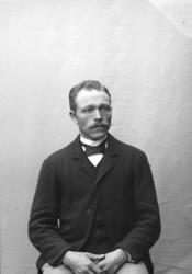 Portrett, mann sitter på stol, brystbilde. Anthon Nilsen