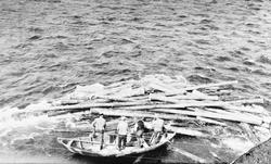 Tømmerfløting, menn i båt. Fløting i Glåma ved Tolga-brua.