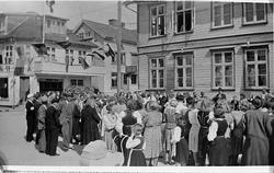 kvinner menn barn flagg bunad hus