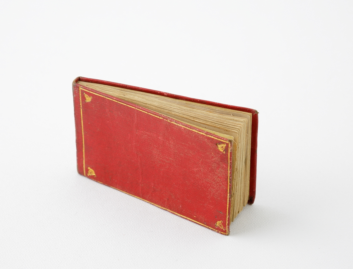 Poesibok.
Mindre, rektangulär bok med pärmar i röd kartong och präglad gulddekor. 
Handskrivna blad med poesi och minnesverser.