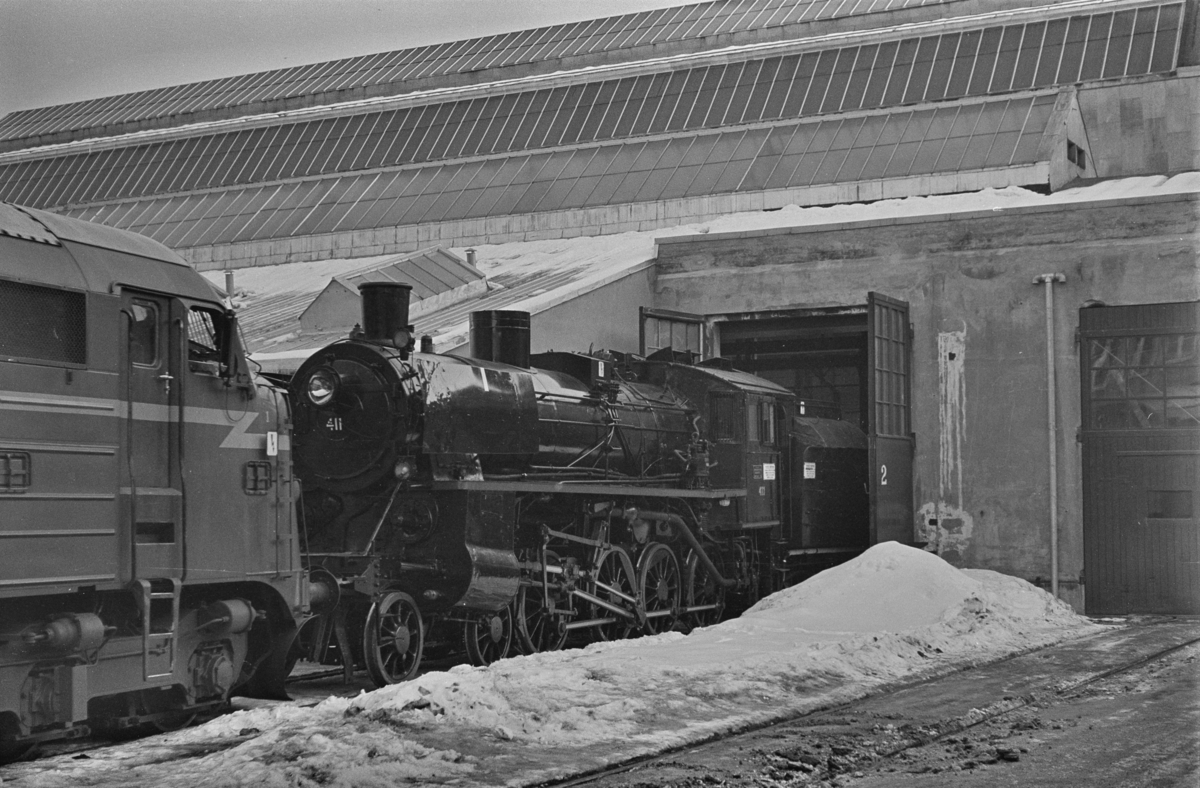 Et nyrevidert damplokomotiv type 26c nr. 411 trekkes ut fra Marienborg Verksted i Trondheim, som det siste damplokomotiv som fikk HR (hovedrevisjon) på dette verkstedet.