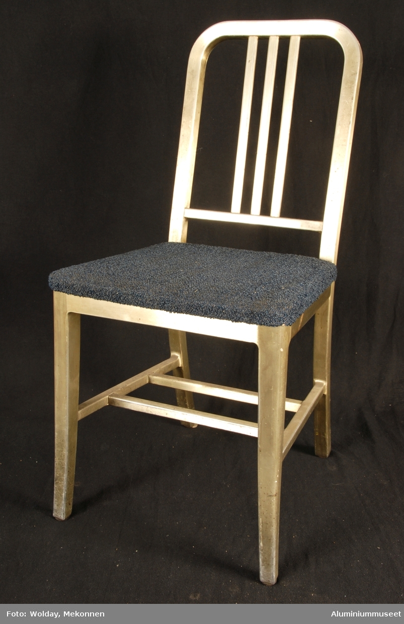 Teknikk: Stolen er delvis håndlaget fra Al-profiler. De er formet i bøyemaskiner og profilene er sveiset, eller skrudd sammen.
Form: Valig spisestuestol-fasong

Under setet er det beskrevet hvordan den skal vedlikeholdes. Artikkelnummer ol.