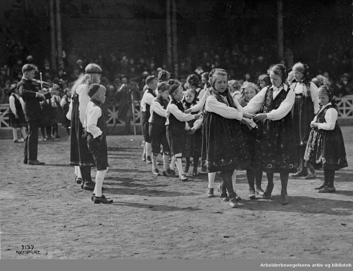 1. mai 1925, fra barnestevnet på Bislett stadion. Leikarring fra et barnelag som opptrer, antakelig en folkedans fra Namdalen "Seierstadhopsa".
