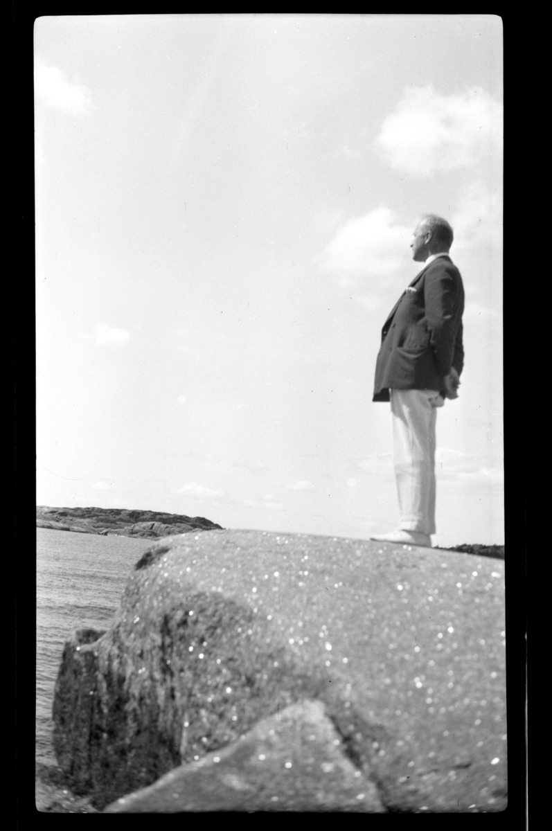 Rolf Sundt Sr. ser ut over sjøen fra et svaberg på Ula, Larvik. Fotografert 1932.