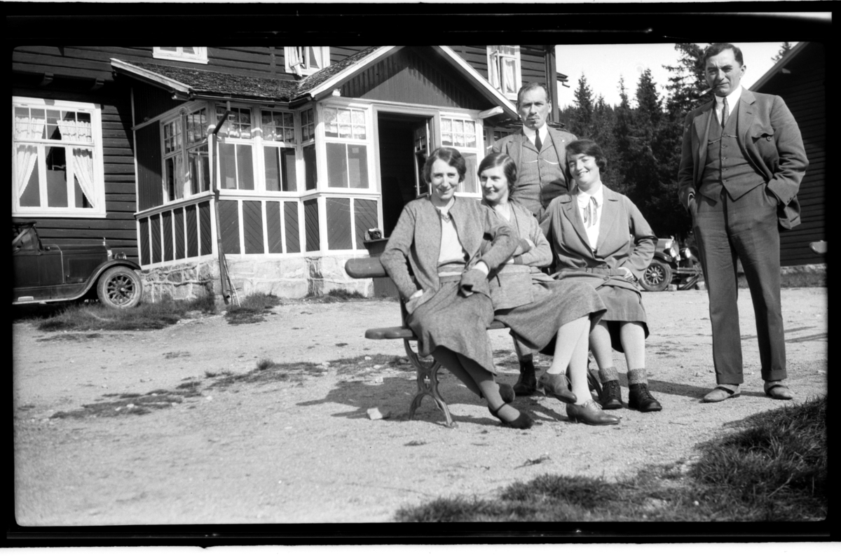 Agnes Buratti, Hilda Sundt, Louis og Ingrid Jersin og Johan Buratti sitter foran en hytte. Fotografert 1930.