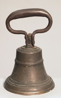 Klocka av brons med kläpp och handtag av smitt järn. Handtaget är fastsatt med två nitar. Auktionsklocka från Hudiksvalls stad.