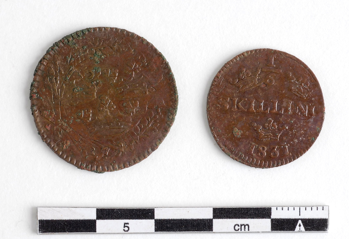 Mynt av kopparlegering. 1/6 skilling banco. Präglat i Avesta 1831, under Karl XIV Johans regeringstid. (Myntet till höger på bilden.)