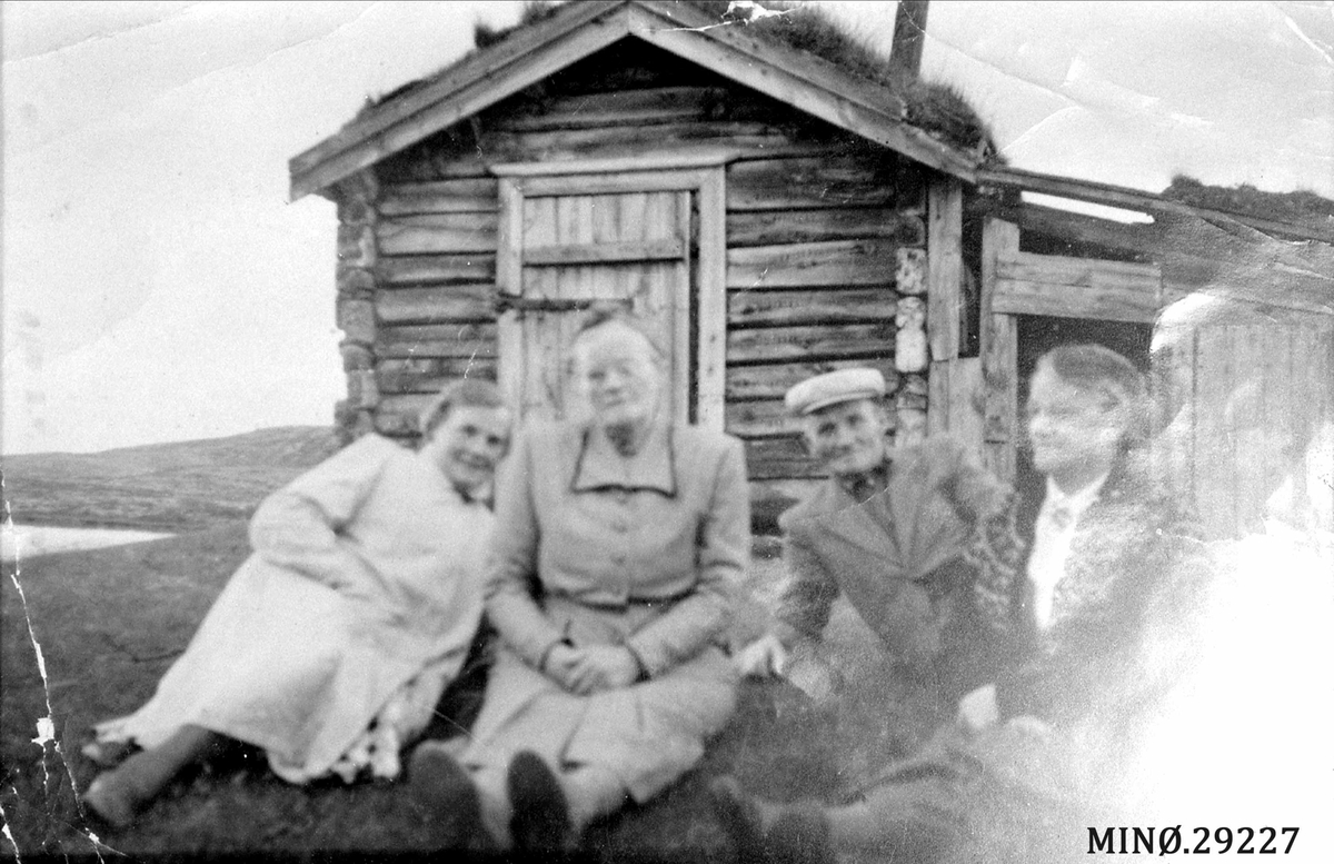 Fire personer foran ei fiskebu. Kvebergsbua ved Breisjøen i ALvdal vestfjell. Den brant i 1923. 
Inga Kveberg f. 1892, Oline Eggen f. 1883, Olaf Kveberg f. 1881 og Olga Kveberg Taraldsteen f. 1892. 
