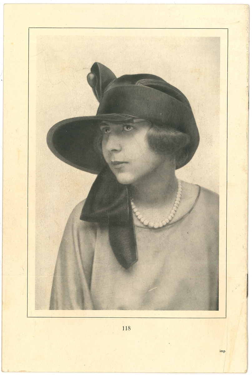 Baksida på modehäfte med en kvinna i hatt. 

Modeller på hattar. Från år 1923. Modejournalen fanns i Amanda Nordahls Modeaffär, Vänersborg.