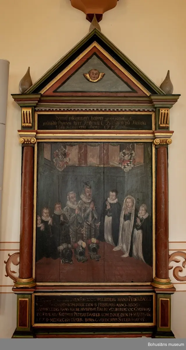 Minnestavla, epitafium, målad på trä. Arkitektonsikt uppbyggd med kolonner på ömse sidor och med ett triangel-format fält (tympanon) upptill.
Motivet visar två riddare i rustning samt tre gossar till vänster, och en äldre samt två yngre kvinnor till höger. Alla är knäböjande.

Bilden har följande text undertill:
"ERLIG WELBYRDIG MAND PEDER BAGGE TIL HOLMEGAARD SOM DÖDE DEN 8 FEBRUARI ANNO 1606 SAMMELEDIS HANS KIERE HUSFRUE ERLIG VELBYRDIG OC GUDFRÖGTIG FRUE FRU KARINNE PEDERSDAATER SOM DÖDE DEN 14 MARTI ANO 1578 MED BEGIS DER BÖRN GUD DERRIS SIELER HAFVE".

Över bilden står det: "Denne Epitaphium hafwer grosshandlaren wälädle Herren herr Fridrich C Bundson på Holma Låtit Renovera Anno 1787.
Epitafiet har ursprungligen hängt i Brastads gamla kyrka som revs 1876. Den ersattes med en ny kyrkobyggnad samma år. 

Ur "Förteckning över lösa föremål av historiskt eller konstnärligt värde som böra vara uppförda i kyrkans inventarieförteckning.
Brastad kyrka, augusti 1918:
Hanna Eggertz, fil. Kand.
Tillhörigt Brastad gamla kyrka förvaras Uddevalla museum:
Kyrkbänk 1670
Maria Magdalena och kvinnligt helgon, träskulpturer, omkr. 1500.
Epitafium över Peder Bagge (+ 1606)"

Ett epitafium är en minnestavla över döda personer.
Epitafiet är sedan 1938 deponerat i Brastad kyrka, se brevväxling m a a ärendet i 238 Topografiska arkivet / Brastad kyrka. Se Placering.

Föremålsfotot är från Uddevalla museums kyrkliga utställning 1920, UMFA54467:0422.
Se bilagor i Bilagepärmen.

Ur Nationalencyklopedien, Internetkälla 2009:
Epita´fium (lat. epita´phium, av grek. epita´phios 'hörande till grav', 'hörande till begravning', av epi- och ta´phos 'grav', 'begravning'), epitaf, inskriftsförsedd minnestavla, uppsatt i kyrka i anslutning till en grav (jfr kenotaf). Epitafier blev vanliga i de protestantiska länderna under 1500- och 1600-talen. De gavs ofta en rik arkitektonisk gestaltning, besläktad med samtida predikstolar och altaruppsatser. Epitafier kan vara av trä, sten eller metall och upptar ofta en andaktsbild samt en målad framställning av den döde och hans familj. Tavlans inskrift kan, förutom data om den avlidne, utgöras av bibelspråk, sentenser eller versifierat epigram. 

Litteratur:
Rydstrand, Sven: Stångenäs. Glimtar ur Bro och Brastad socknars historia. 1958, s.68 - 69, 71.
Rydstrand, Sven:  Brastads kyrka i Bohuslän, Historik och beskrivning, 1976.