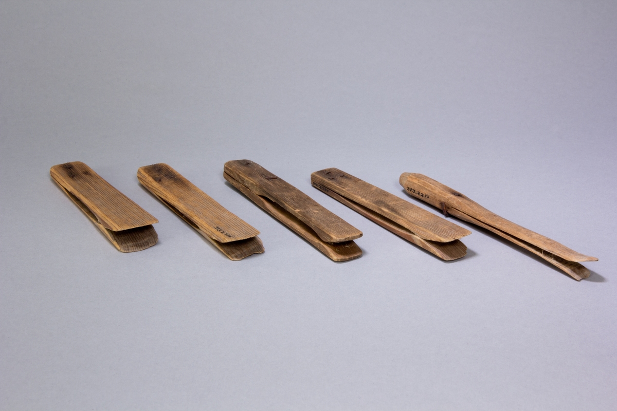Klädnypa, 5 st, tillverkade av avlånga träplattor sammanfogade två och två med 1-3 spikar. De är något olika utformade.