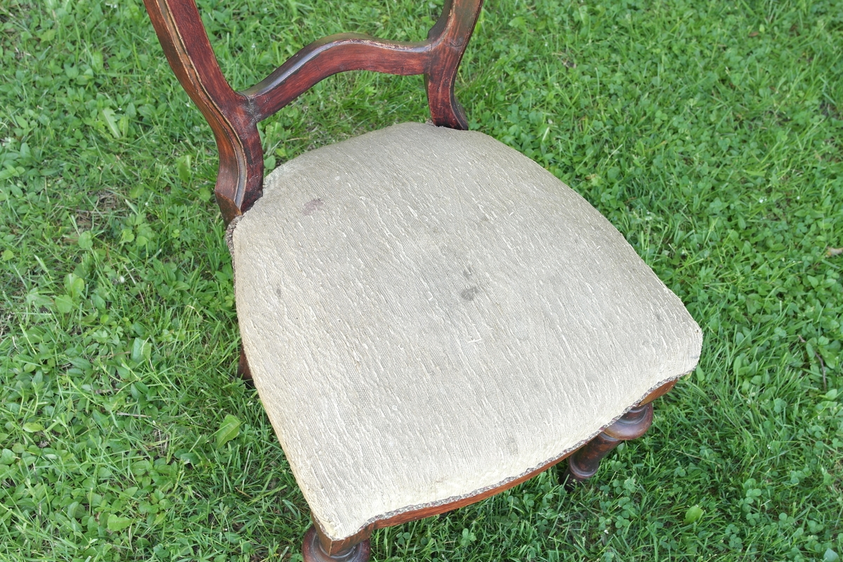 Stol i beiset mørk rødbrun bjørk. De to forreste beina er dreiet. Stolen har sete i stripemønstret stoff. Et tvunnet tau i ulike farger er festet rundt kanten. Det er fem stålfjærer i setet. På toppen av seteryggen er det inngravert et heksagon med en T inni.

Denne stolen er stilmessig lik stol SFS0656.