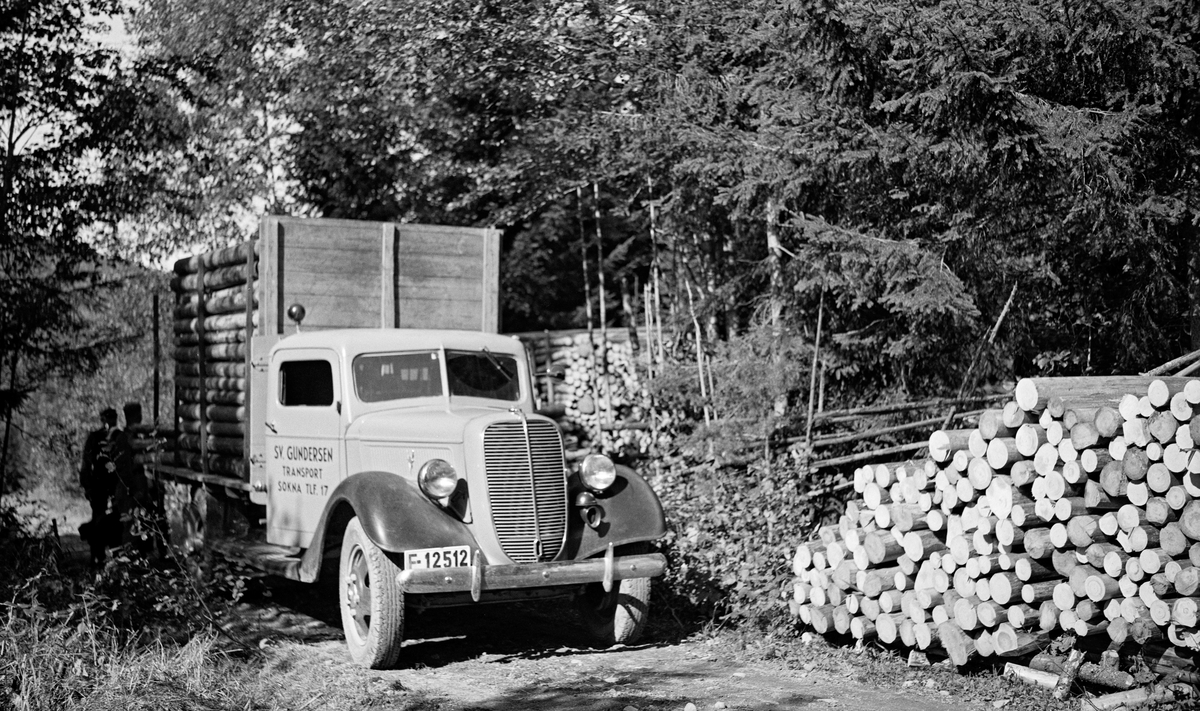 Tansport av cellulosekubb med lastebil fra Borgerud i daværende Norderhov kommune på Ringerike i september 1937.  Bilen er en Ford V8 1937-modell med transportørens navn og telefonnummer på døra til det norskbygde førerhuset: «Sv. Gundersen transport  Sokna Tlf. 17».
