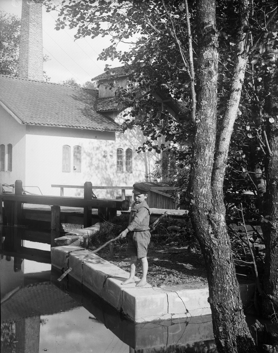 "John Hallströms son metar fisk i kvarndammen", Forsby, Simtuna socken, Uppland 1922