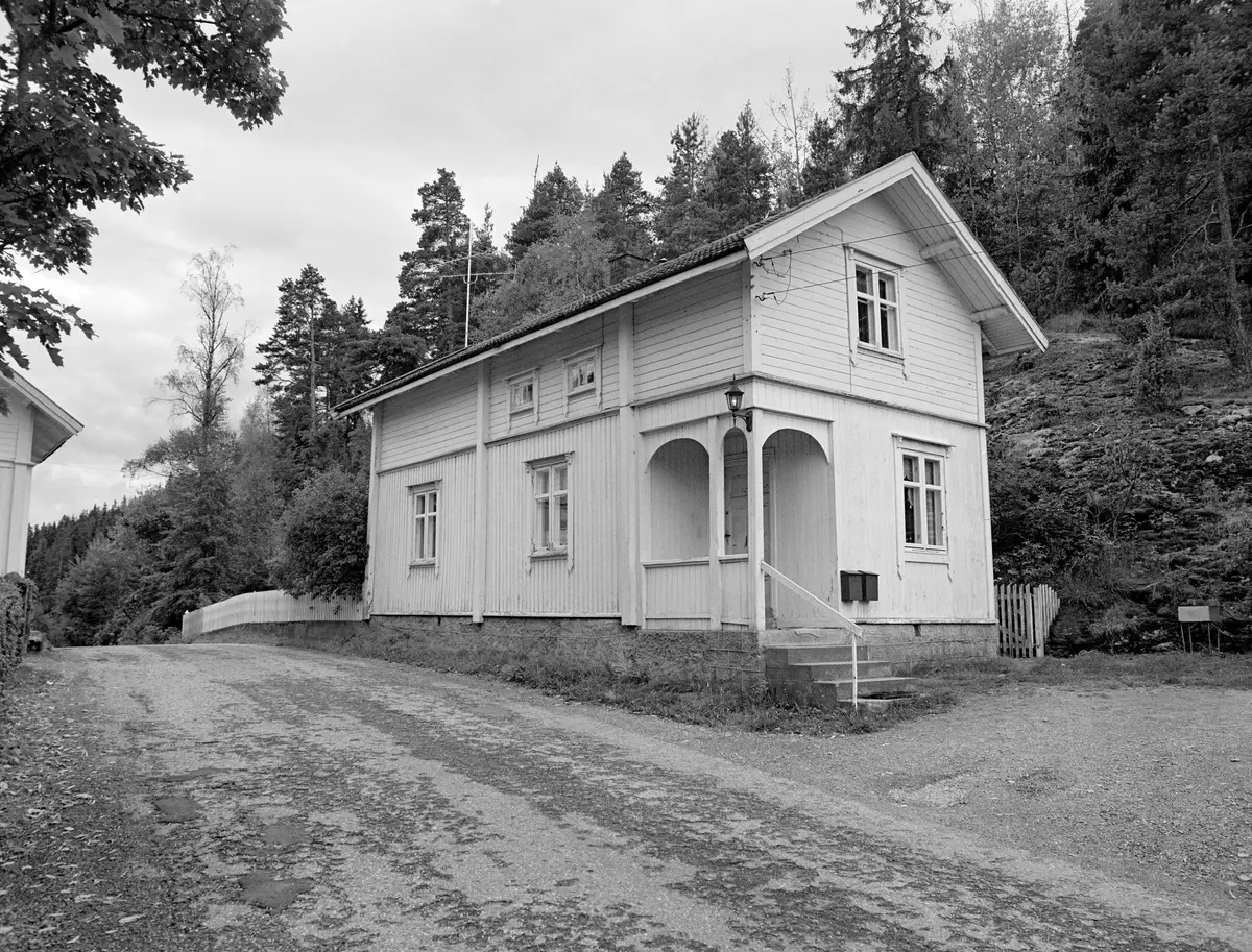 Sluseassistentboligen ved Ørje sluser i Marker i Østfold (Haldenvassdraget).  Fotografiet viser et forholdsvis smalt, lite våningshus i halvannen etasjes høyde.  Bygningen later til å være reist på et fundament av kvadrete granittblokker.  På hjørnet mot vegen [og fotografen] er det ei støpt trapp opp mot et åpent inngangsparti.  Veggene er bordkledde, med vertikalstilt panel på den nedre etasjen og horisontaltliggende kledning på den øvre halvetasjen.  Vertikale kasser som stikker ut fra det øvrige vegglivet skjuler muligens laftehodene i bakenforliggende konstruksjoner.  Bygningen har krysspostvinduer, samt to todelte mesaninvinduer på midtre del av langveggen.  Eksteriøret er kvitmalt.  Over det hele ligger et saltak med forholdsvis vide utskott.  Endene på åser og sperrer har en profilert avslutning.  Langs bygningens østside går det en veg.  På østsida (bakenfor) skimter vi et skogbevokst berg.  Ørje sluser hadde også en slusemesterbolig, jfr. SJF-F.009182.

Det første sluseanlegget ved Ørje ble bygd i perioden 1857-1860, og fra 1877 ble tømmer fra de øvre delene av vassdraget fløtet ned til industrien i Halden på et kanalisert vassdrag.  En kort historikk om fløtinga i Haldenvassdraget finnes under fanen «Opplysninger».