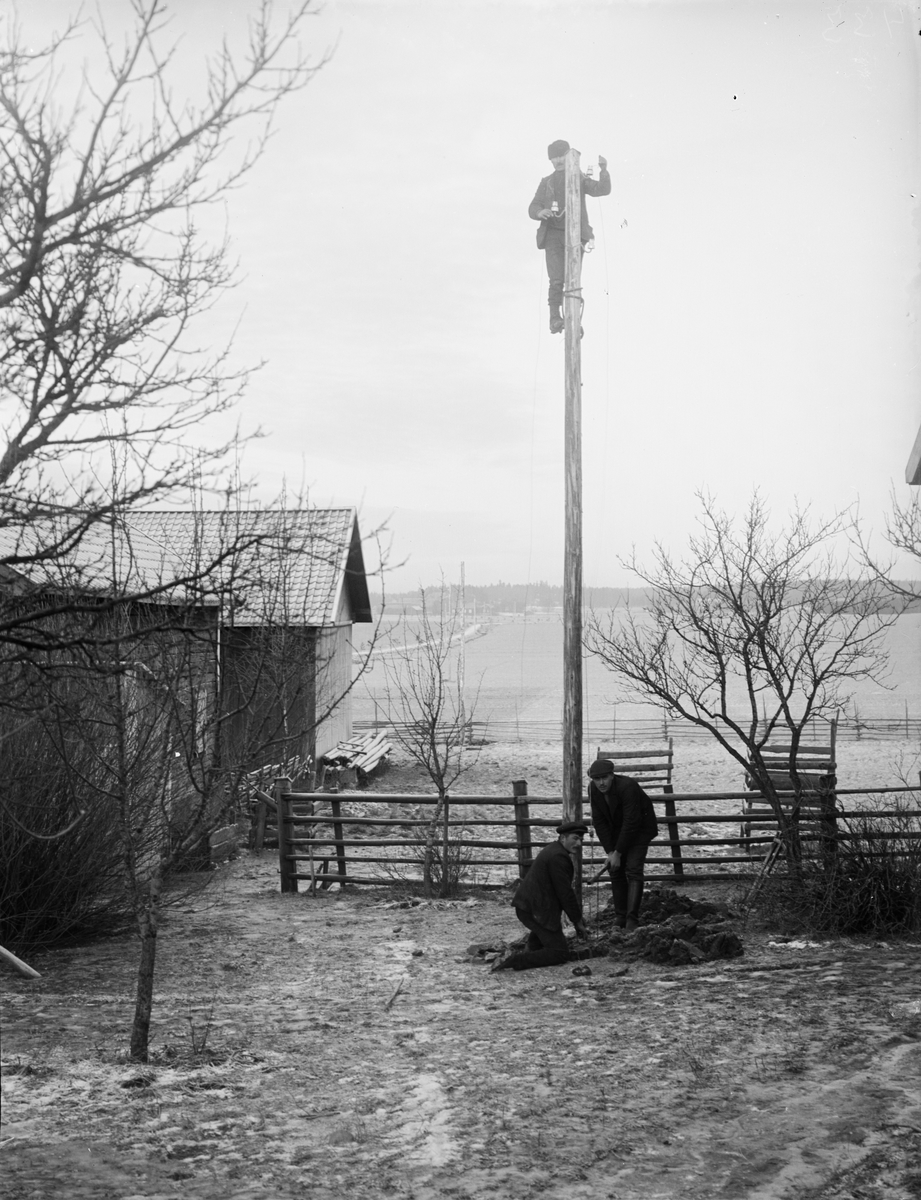 Tre män sätter upp el- eller telefonstolpe, Sävasta, Altuna socken, Uppland