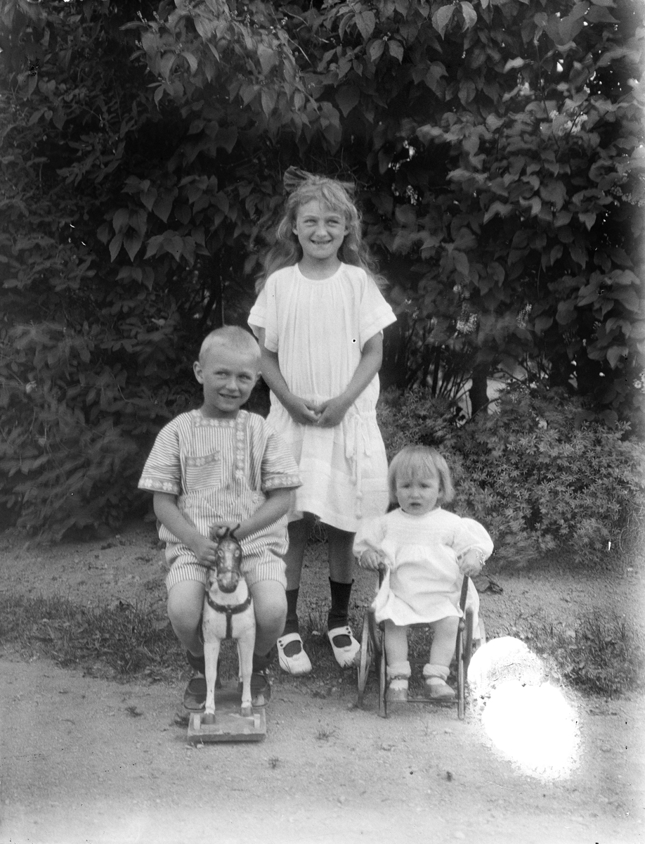 "Telins barn med trähästen" i trädgården i Fröslunda, Altuna socken, Uppland 1923