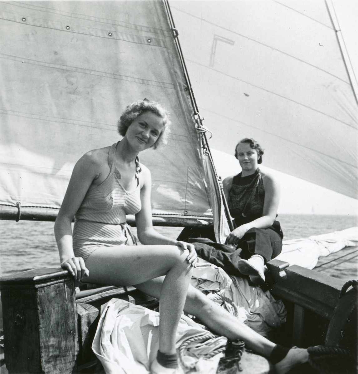 Två kvinnor i solkläder på däck.