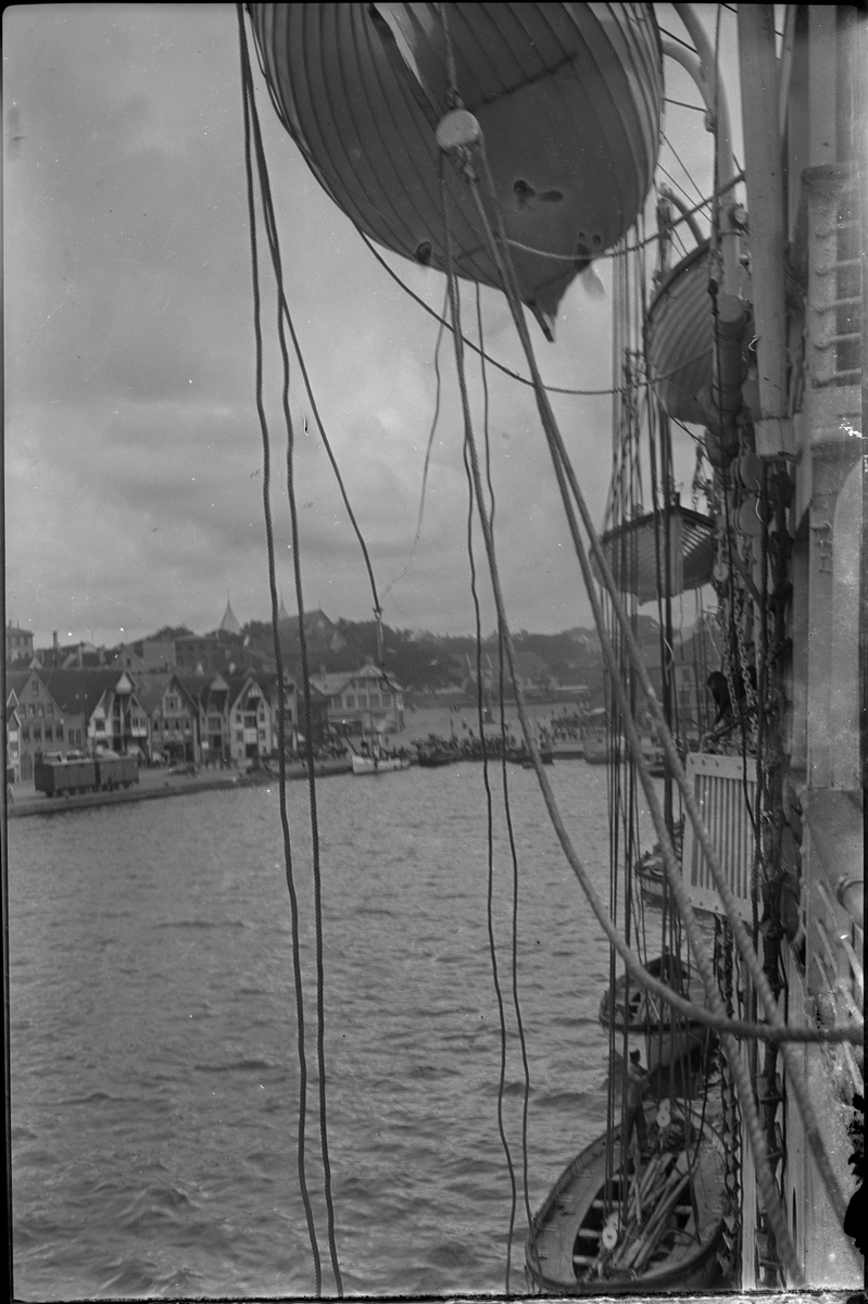 Mannskapet på "D/S Neuralia" er stilt opp for fotografen. Det også bilder tatt fra skipet av Vågen i Stavanger. Et bilde er av et korps med sekkepiper og trommer.