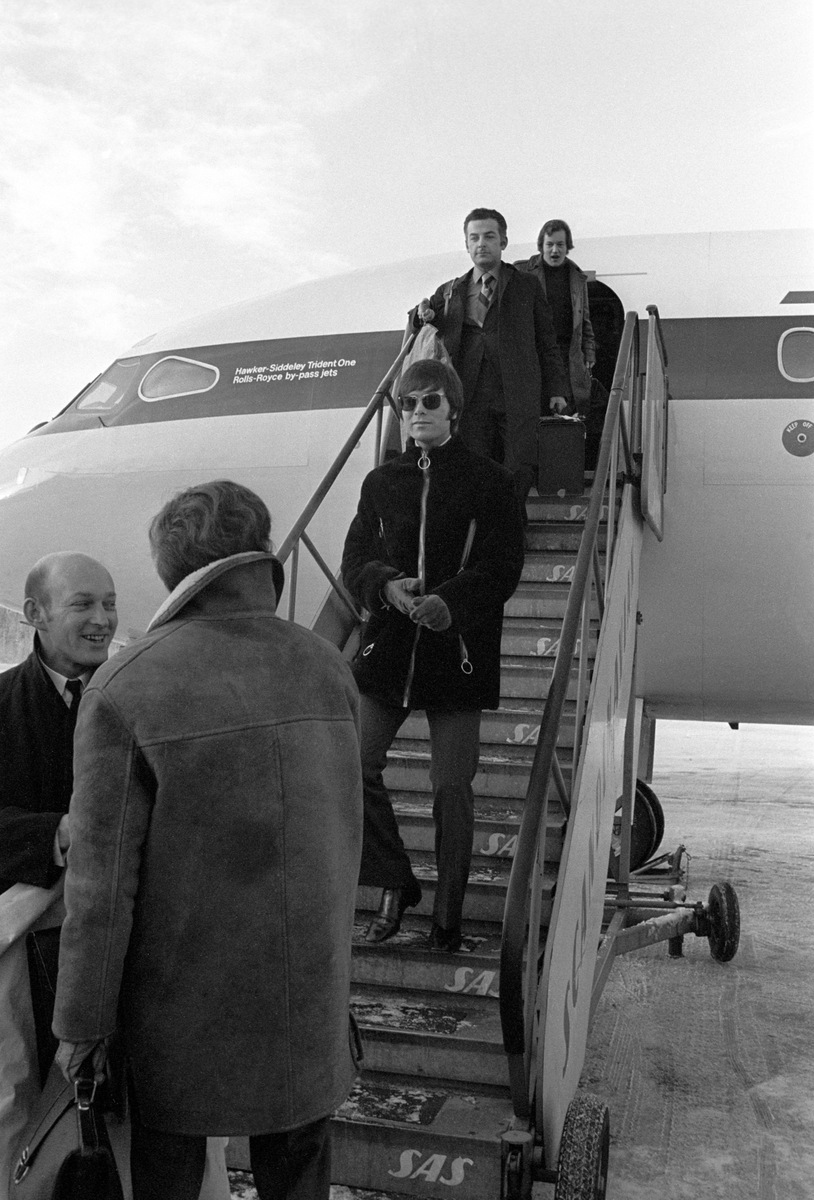 Popsanger Cliff Richard ankommer Fornebu på vei til Bergen. Cliff på vei ned flytrappa.