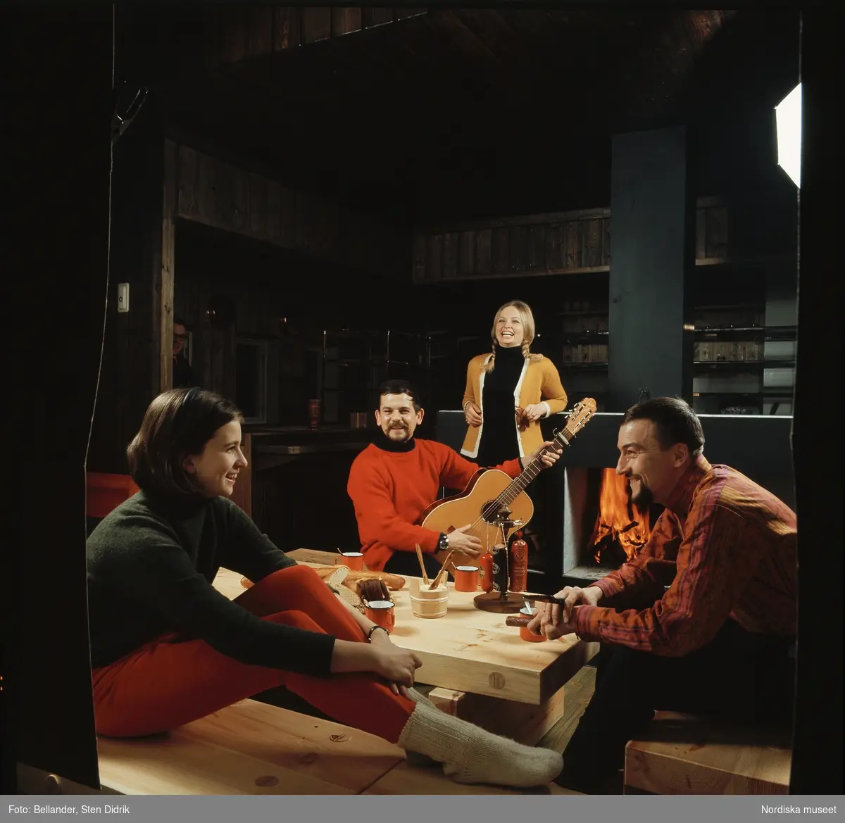 Grupp vid bord med gitarrspelande man