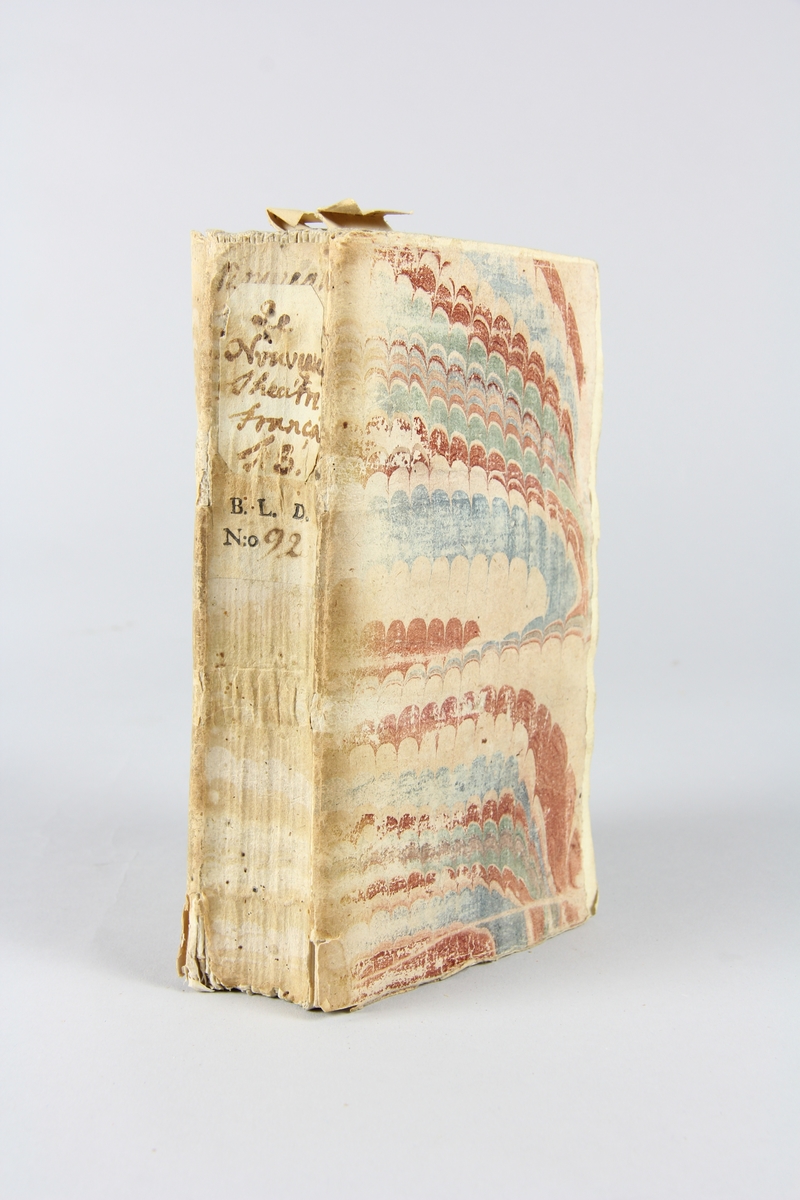 Bok, häftad, "Le nouveau théâtre françois", del 8, tryckt i Utrecht 1736.
Pärm av marmorerat papper, oskurna snitt. På ryggen klistrade pappersetiketter med volymens namn och samlingsnummer. Ryggen blekt.