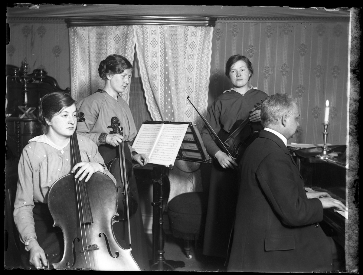 Anna, Eva & Edith Claesson och far (troligen fotografen Harald Olssons far) spelar fiol, cello och piano.