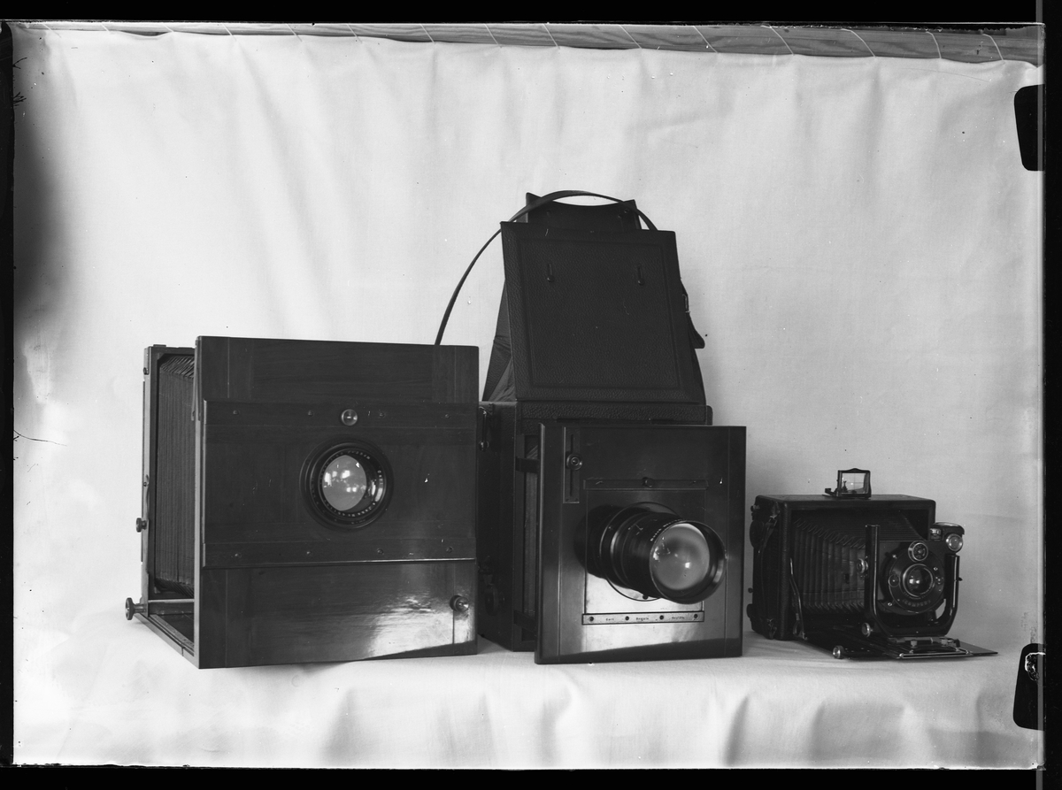 Tre kameror uppställda mot vit bakgrund. I fotografens egna anteckningar står det "Mina tre största kameror"