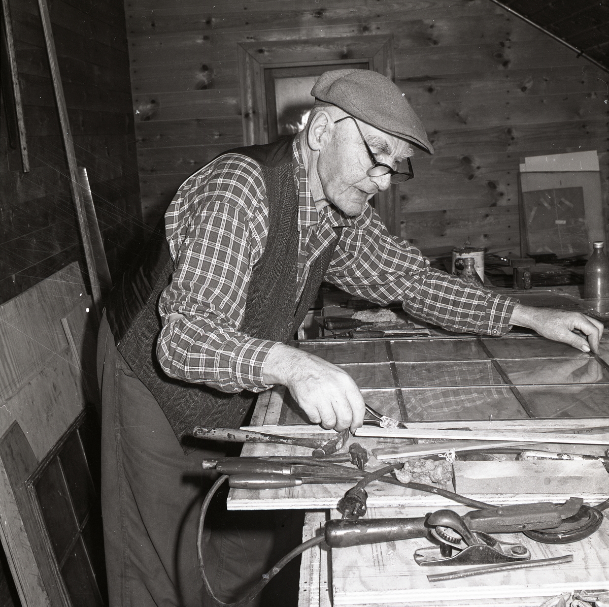 En man arbetar koncentrerat vid en bänk, 1968.