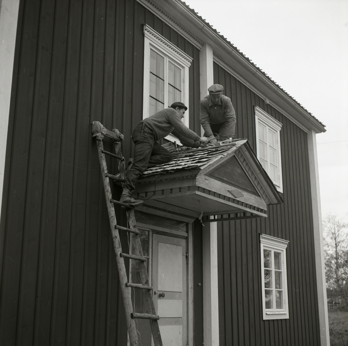 Två män lägger tak på förstukvisten vid gården Sunnanåker, 1967-68.