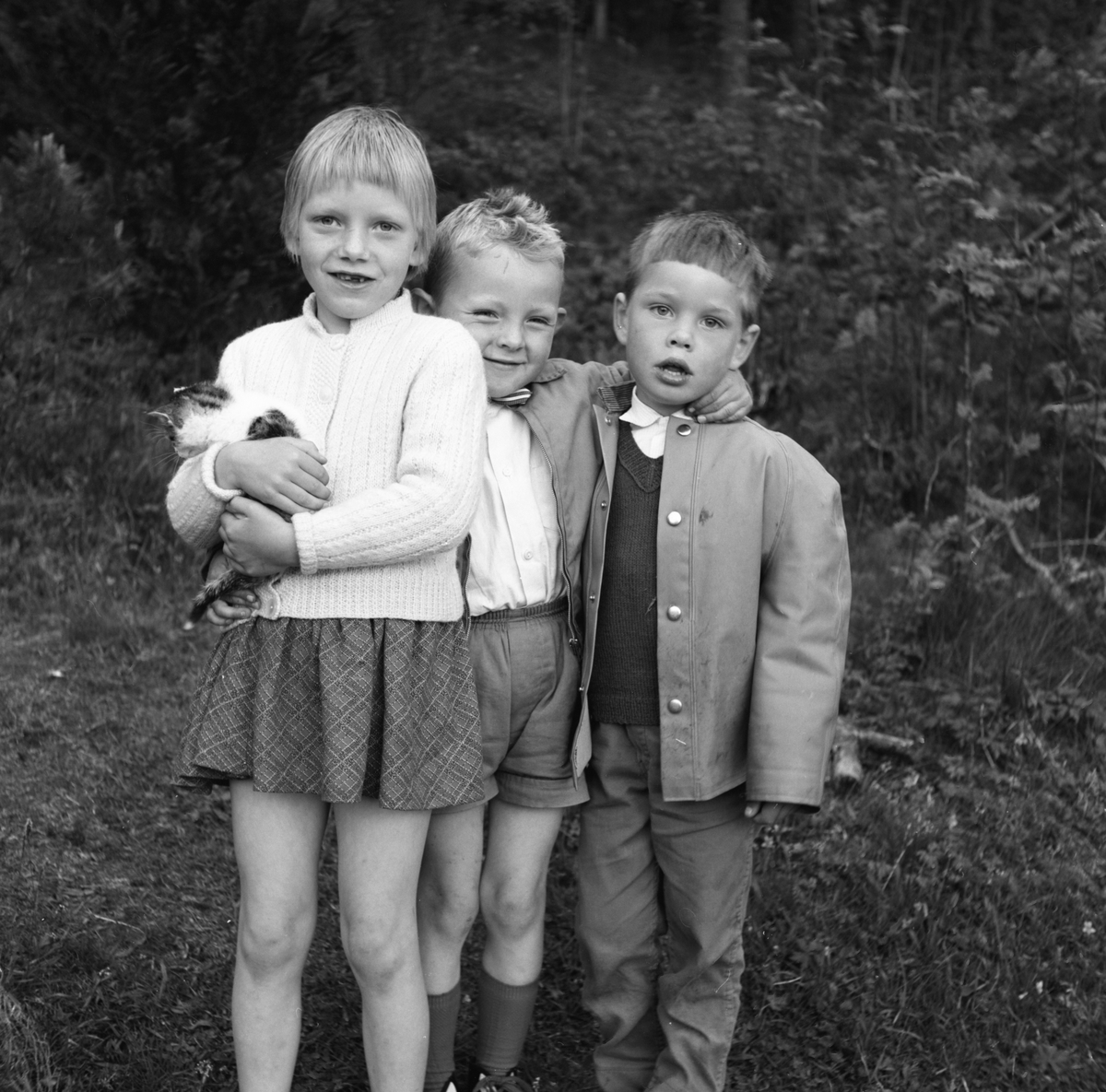 Portrettfotografi av tre barn. Den ene med en kattunge i armene. Karsten Aa. N.(midten) feirer sin bursdag.