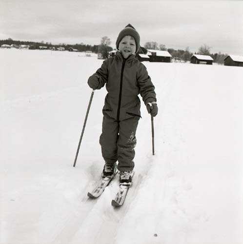 En pojke på längdskidor står i ett längdspår, 1984.