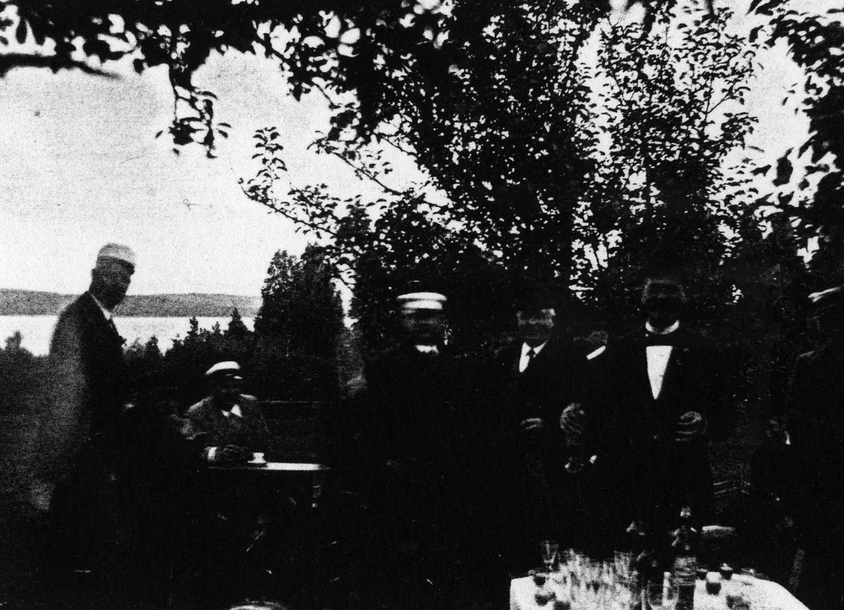 Sju män i kostym och studenmössor vid bord dukat med glas och flaskor. Bilden tagen utomhus med en sjö i bakgrunden.
Alingsås herrklubb cirka 1895. På bilden syns: C.A. Ericson, J.A. Berger, Alfred Hedén, Th. Olsson, W.E. Norén, J.A. Bergmark, Gustav Nilsson