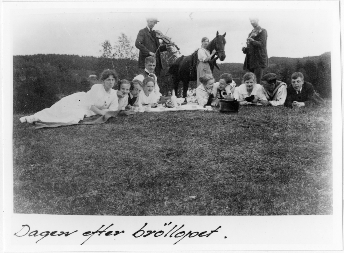 Ett tiotal personer från Nils och Elisabeth Hennnings bröllop fotograferade dagen efter festen.

Nils Henning och hans hustru Elisabeth född Ekholm (hon liggande som nr 4 från vänster), han sittande vid hennes sida. Spelmän från Ödenäs varav en troligen hette Olsson. Nils var lärare i Ödenäs från 1915 och familjen bodde i skolan.
