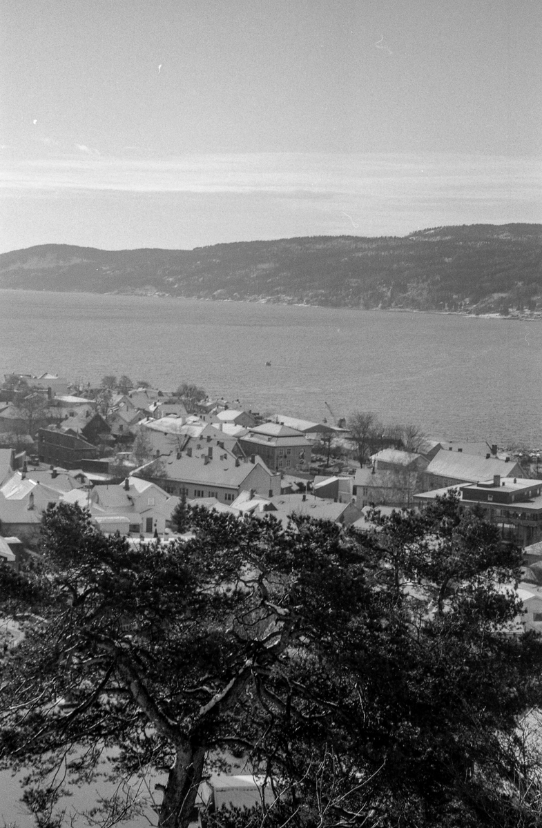 Utsiktsbilde over Frogn og Drøbak over Oslofjorde mot Hurumlandet. Vinterlandslap med småhusbebyggelse og blokker.