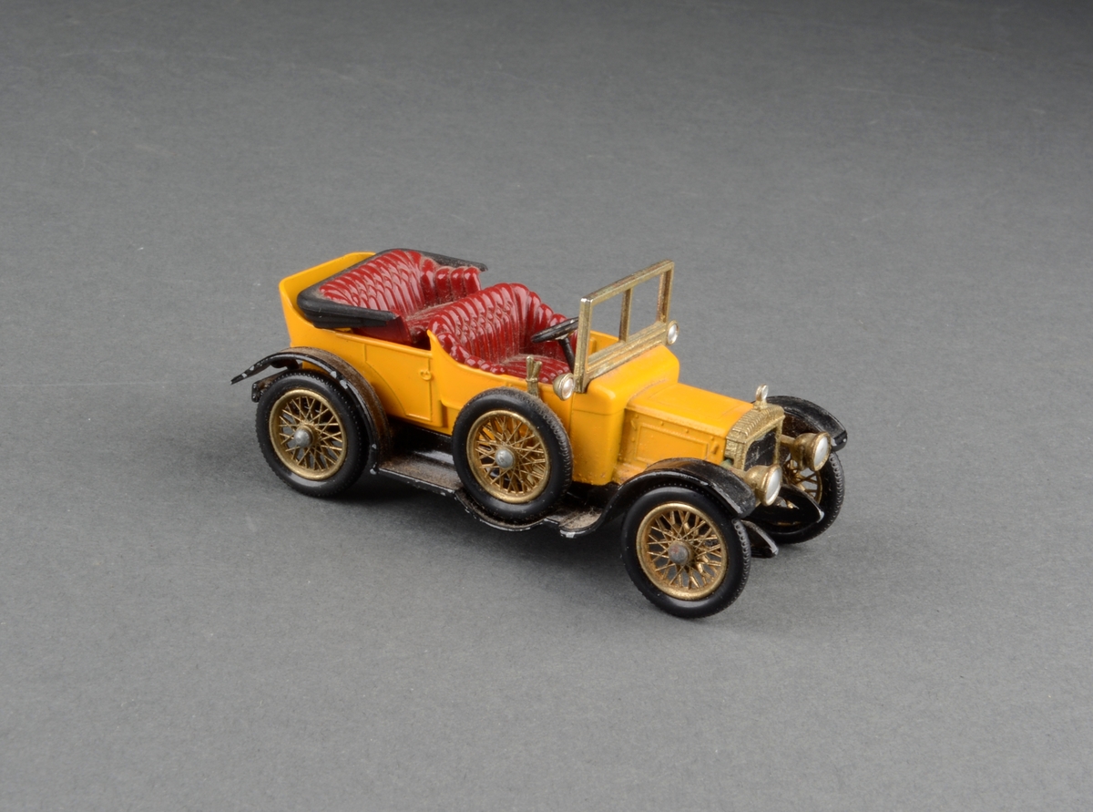 Modell av en 1911 Daimler kabriolet med reservehjul på siden. I originaleske