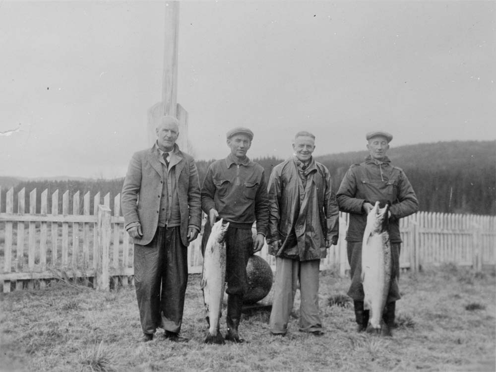Roerne Olaf Turmo til venstre og Knut Forsjord med hver sin stor laks, sammen med to engelske sportsfiskere. På Forsjorda, Forsbakken, etter 2. verdenskrig.