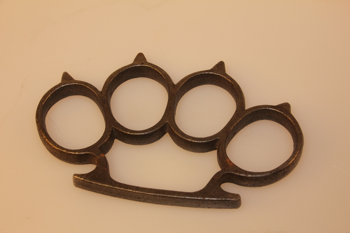 Knokejernet er bygd opp av fire ringar som ein trer på fingrane, med ei metallbøyle som ein held inne i handa.