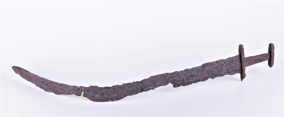 Tveegget sverd i jern av typen R. 489 fra vikingtiden. Funnet på Gile 1909. Klingen noe krøkt.
