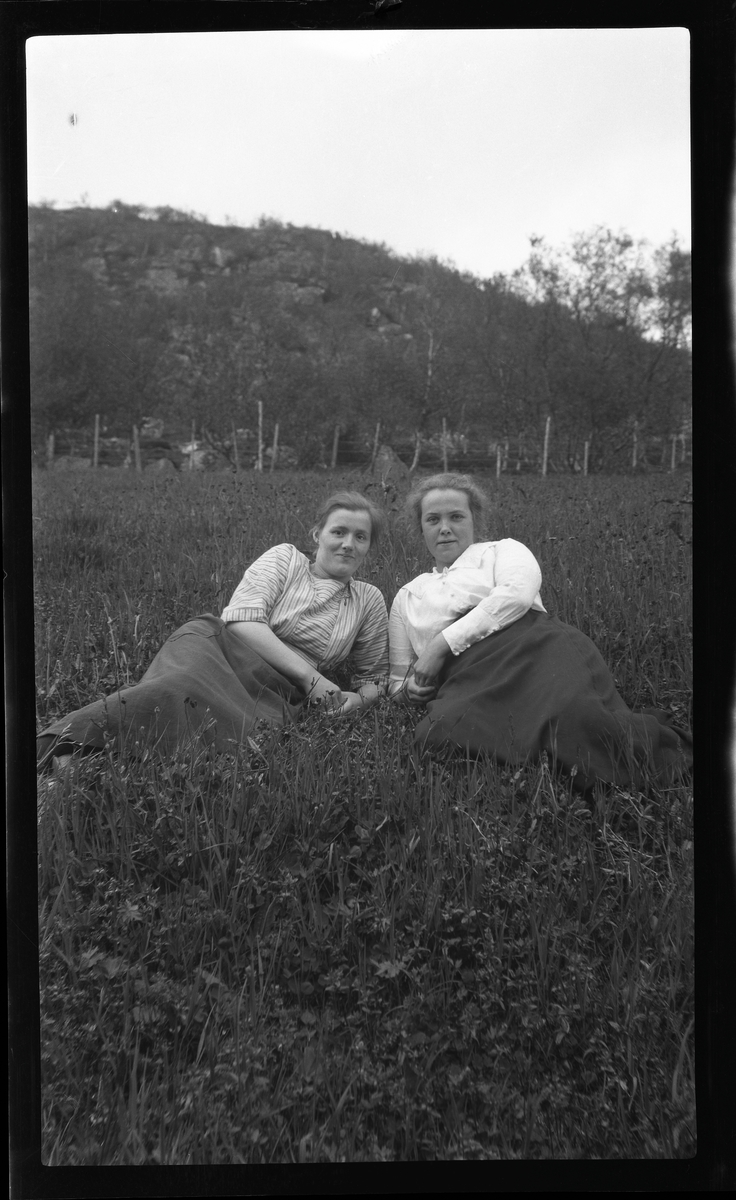 Margrete og Elly Haranda Heide, fotografert liggende på marka.