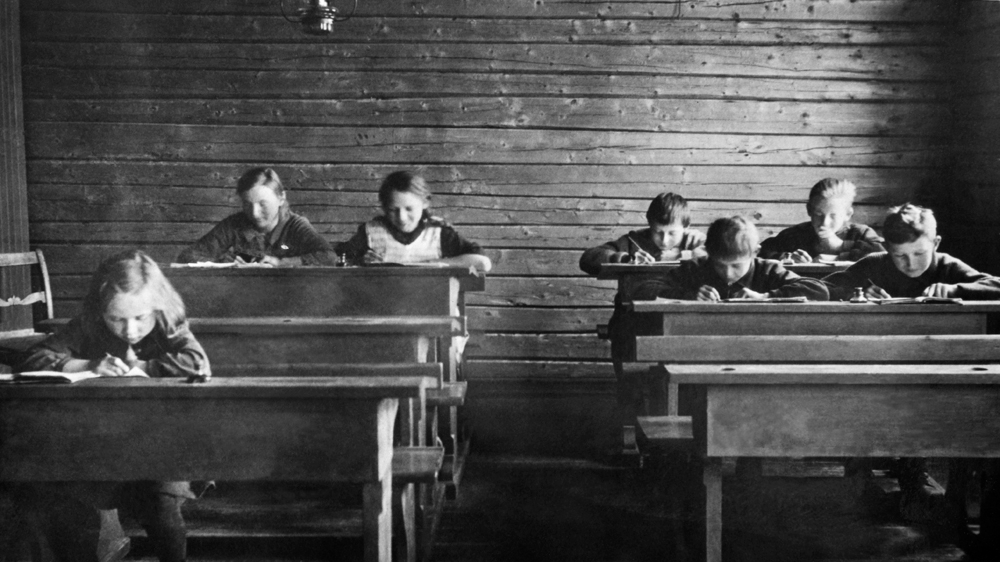 Interiør fra skolestua i Hundåla. Elever ved pultene. I midten bak, Solveig f.1918 og Åsmund f.1920.