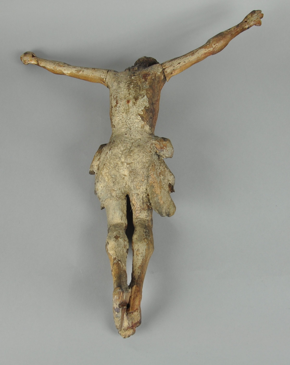 Figur av tre, forestiller Jesus med armene utslått. Figuren hører opprinnelig til en Barokk altertavle. Enkelte sprekker i treverket, spesielt ved mage og torso.